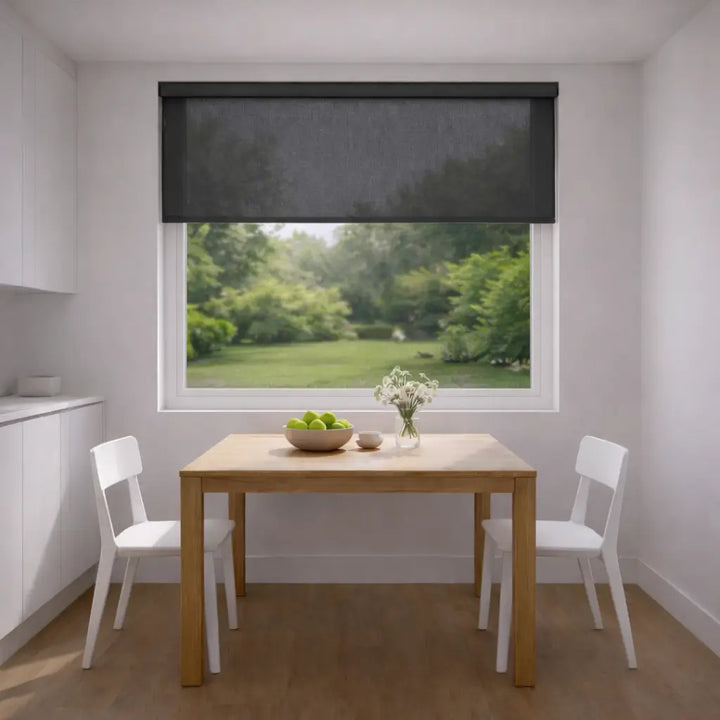 Modern kitchen with the charcoal sunscreen shade lowered, showing the table in a soft shadow with the backyard view preserved through the mesh weave.