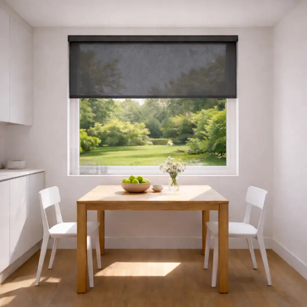 Modern kitchen with a charcoal sunscreen roller shade partially open, showing harsh sunlight glare on a wooden table.