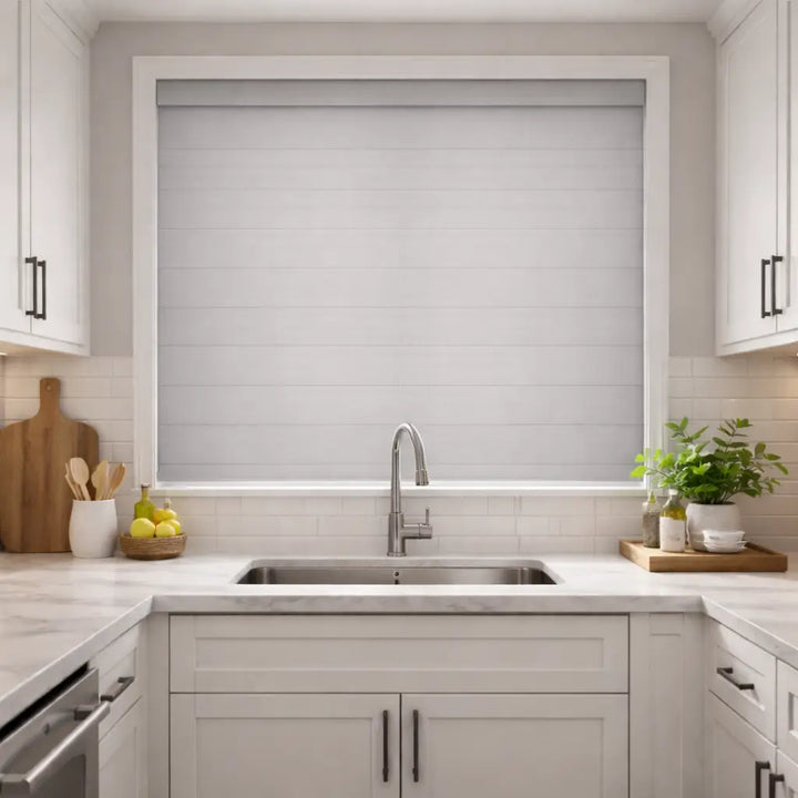 Soft Gray Semi-Blackout Zebra Shades in the closed position, providing privacy and a soft filtered glow in a kitchen.